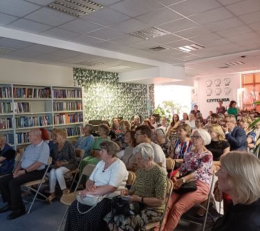 grupa osób siedzi na krzesłach