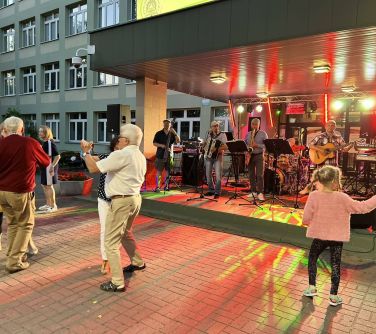 osoby tańczą na dworze na scenie kapela