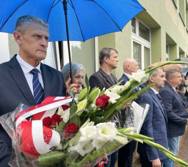 grupa ludzi z parasolami i kwiatami