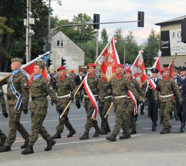 poczty sztanadowe i flagowe jednostek maszerują pod pomnik