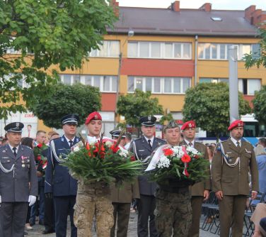 reprezentacja służb munrurowych niesie wieniec pod pomnik