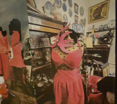 stroje założone na manekinach, w tle witryny z artystycznym bałaganem, na górze na ścianie obraz i ozdobne talerze