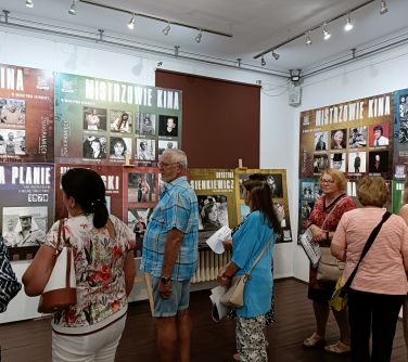 osoby zwiedzają w pomieszczeniu wystawę