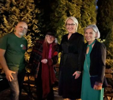 cztery osoby pozują do zdjęcia, po lewej stronie dwóch mężczyzn, po prawej dwie kobiety, zdjęcie w nocy, w tle krzewy