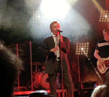 mężczyzna śpiewa na scenie