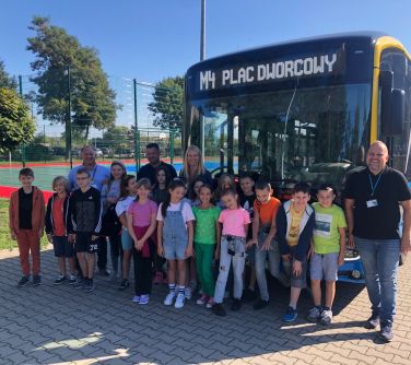 grupa osób pozuje na przodzie autobusu elektrycznego M4 Plac Dworcowy