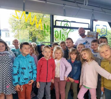 dzieci pozują do zdjecia w zeroemisyjnym autobusie