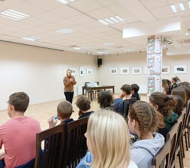 nastolatki siedza na krzesłach słuchają wykładu kobiety