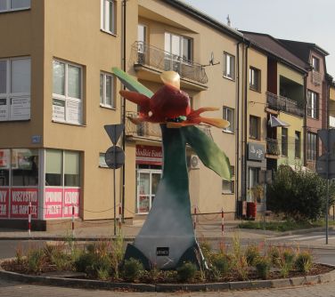 rzeźba kwiatowa na rondzie, w tle bloki