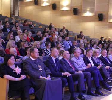 publiczność siedzi na fotelach na sali koncertowej