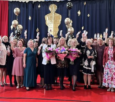 grupa odświętnie ubranych osób pozuje do zdjęcie, w tle dekoracja balony, zrobiony oscar