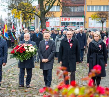 delegacja pięciu osób składa wiązankę pod pomnikiem niepodległości, w tle pozostałe osoby