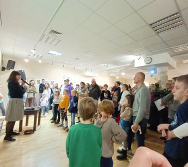 Aula. Zgromadzone osoby słuchają kobiety która przemawia do mikrofonu