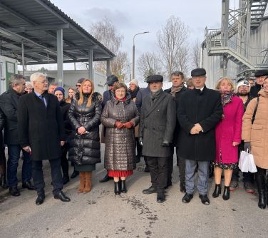 Dwór, nowoczesna oczyszlania ścieków. Duża grupa osó pozuje do zdjęcia