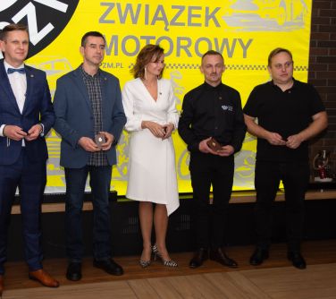 Pomieszczenie. Pięć osób pozuje do zdjęcia. W tle baner związek motorowy