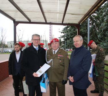 Na dworze. Trzech uśmiechniętych mężczyzn pozuje do zdjęcia