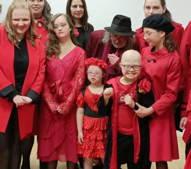 Pomieszczene. Dziewięć osób w czerwono-czarnych ubraniach