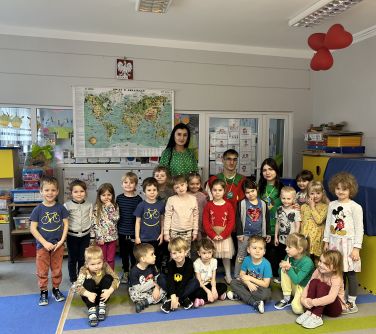 Sala przedszkolna. Grupa dzieci wraz z trzema dorosłymi pozuje do zdjęcia