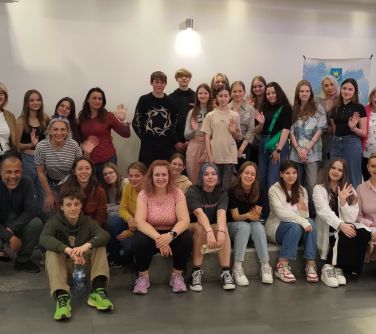 Pomieszczenie. Uśmiechnięta grupa osób pozuje do zdjęcia