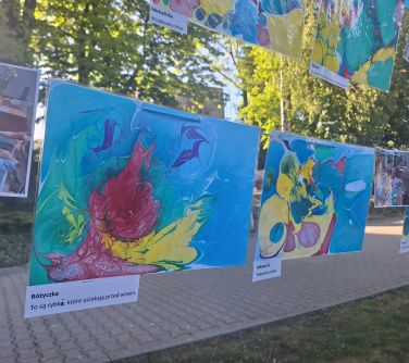 Dwór. Zdjęcie kolorowych prac dzieci powieszonych na sznurkach