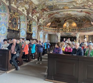 Grupa osób zwiedza wnętrze budynku z malunkami na ścianach