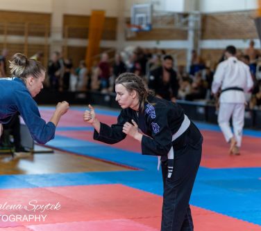 Hala sportowa. Dwie kobiety w kimonach w układnie stoją na przeciwko siebie