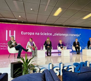 Pomieszczenie. Na scenie sześć osób siedzi na fotelach. Trwa debata. W tle różowo-niebieska duża ścianka