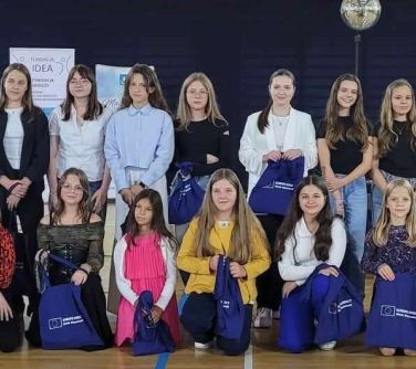 Hala sportowa, dzień. Grupa dzieci z granatowymi torbami. Na przodzie część kuca, reszta w drugiej linii stoi