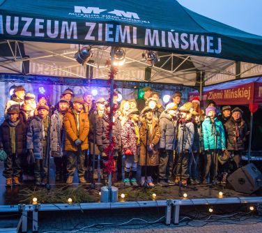 Zapadający zmierz. Na zadaszonej scenie grupa dzieci wystepuje.