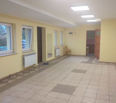 Oświetlone wnętrze korytarza. Po lewej okna. Ściany pomalowane na żółto