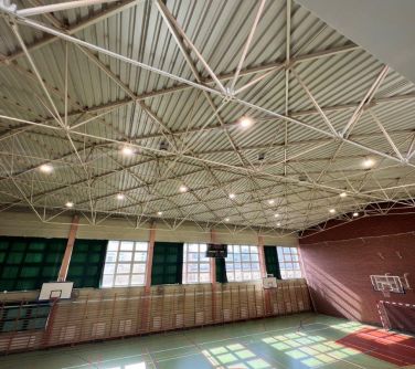 Oświetlona sala gimnastyczna. Zdjęcie z góry z widokiem na podłogę. Za oknem dzień
