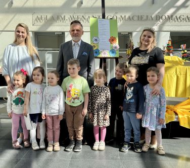 Jasna aula. Troje dorosłych, przed nimi siedmioro dzieci