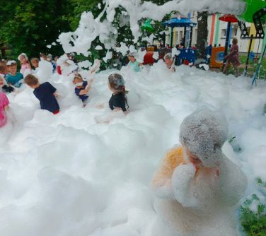 Na dworze, dzień. Dzieci bawią się ogromnej ilości piany